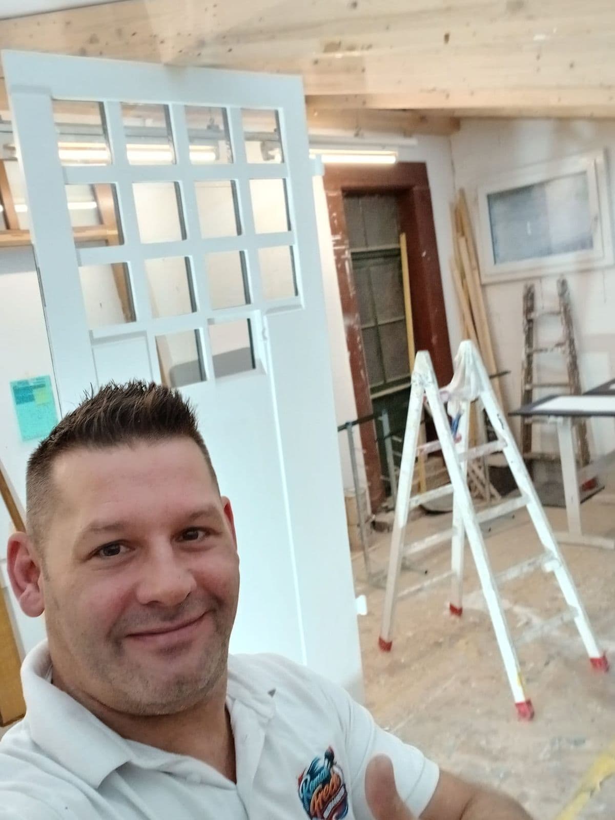 Roman Frech in der Schreinerei vor einer frisch lackierten Sprossentür