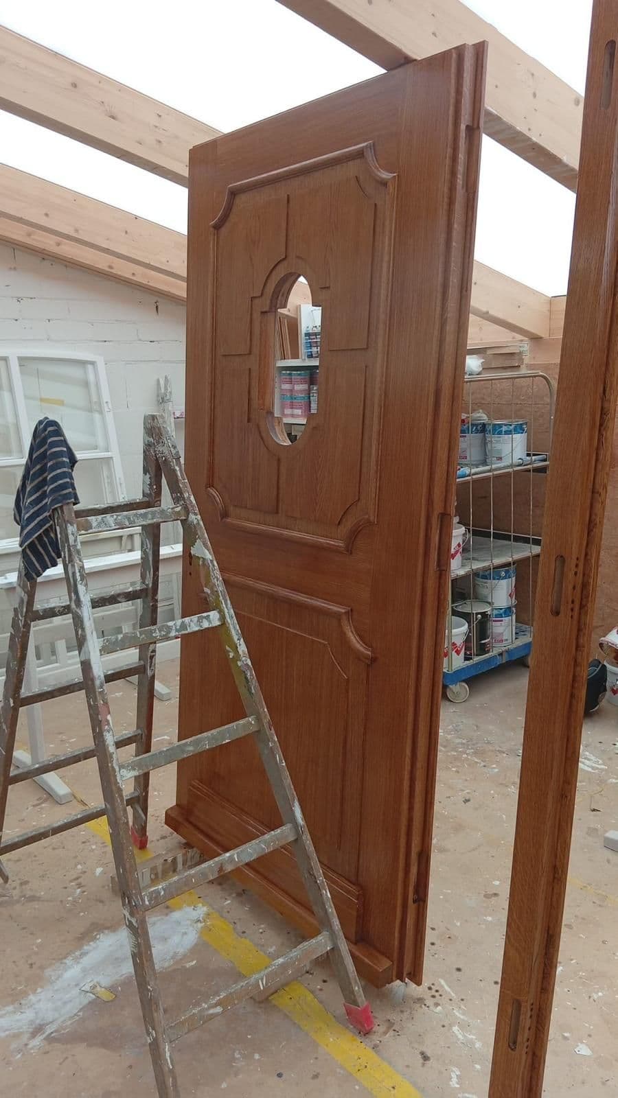 Massive Eichentür mit ovalem Glas nach dem Lackieren