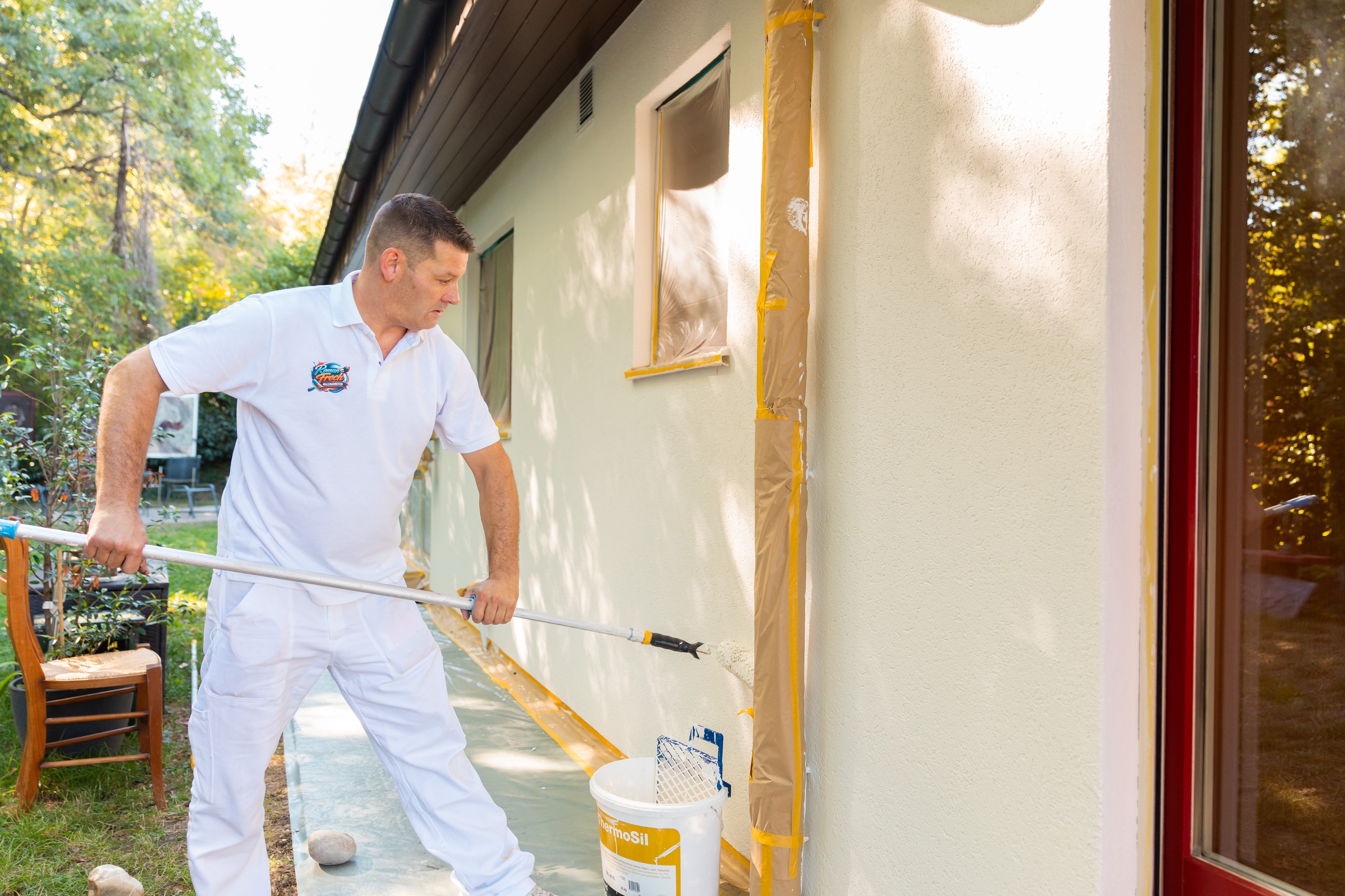Roman Frech bei einer Malerarbeit an einer Fassade